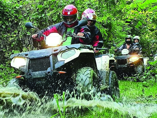 Quadovi u vožnji kroz vodu i blato na šumskoj stazi